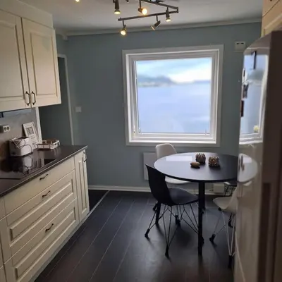 a kitchen with a table and a window at Fjord view in centre with parking in Ålesund