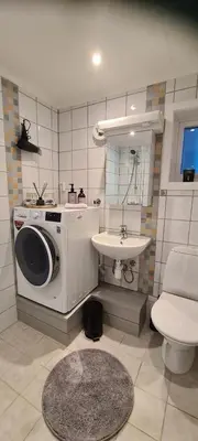 a bathroom with a washing machine and a sink at Fjord view in centre with parking in Ålesund
