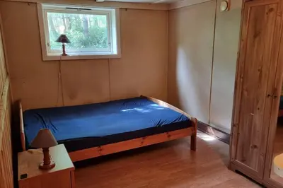 a small bedroom with a bed and a window at House in Austevoll in Austevoll