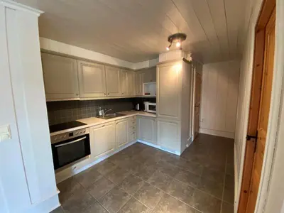 a small kitchen with white cabinets and appliances at Ruud Tun in Hafjell