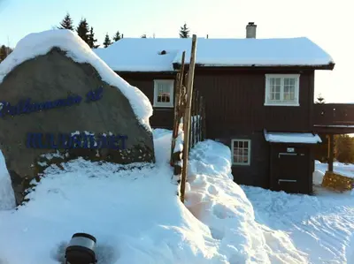 a house with a snow covered rock in front of a house at Ruud Tun in Hafjell