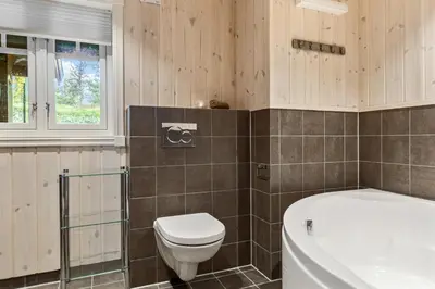 a bathroom with a toilet and a tub and a sink at HYTTEEVENTYR I VALDRES MED JACUZZI, 5 soverom, alpinbakke og skiløyper like ved! in Aurdal