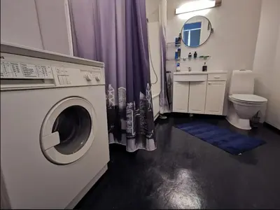 a bathroom with a washing machine and a toilet at Private room in central homestay apartment with sea view in Ålesund
