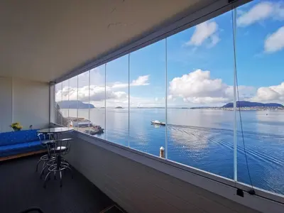 a large window with a view of the water at Private room in central homestay apartment with sea view in Ålesund