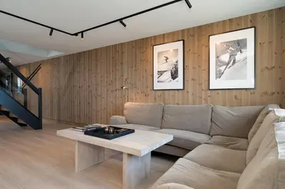 a living room with a couch and a table at Stølstunets toppetasje in Beitostøl