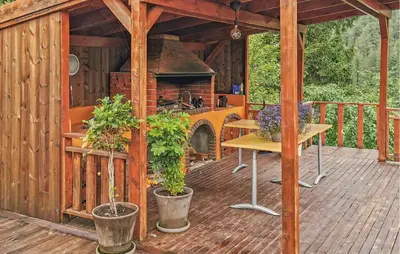 a wooden deck with an outdoor kitchen in a house at Gorgeous Home In Førde in Førde