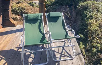 a green lawn chair sitting on a wooden deck at Lovely Home In Uvdal With Sauna in Uvdal