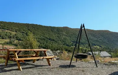 a picnic table and a bench and a grill at Lovely Home In Uvdal With Sauna in Uvdal