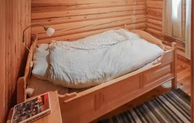 a bedroom with a bed in a wooden wall at 2 Bedroom Lovely Home In Oppdal in Oppdal