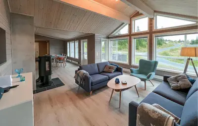 a living room with a blue couch and a table at Gorgeous Home In Svingvoll With Wifi in Svingvoll