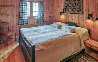 a bedroom with a large bed in a room with wooden walls at Stunning Home In Rjukan With Sauna in Rjukan
