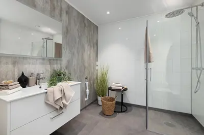 a white bathroom with a shower and a sink at Modern apartment with two bedrooms in Moelv