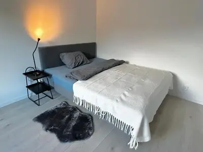 a bedroom with a bed with a blanket and a lamp at Modern apartment with two bedrooms in Moelv