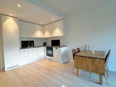 a kitchen and dining room with a table and chairs at Modern apartment with two bedrooms in Moelv