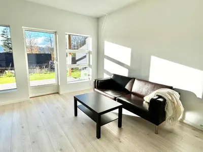 a living room with a leather couch and a table at Modern apartment with two bedrooms in Moelv