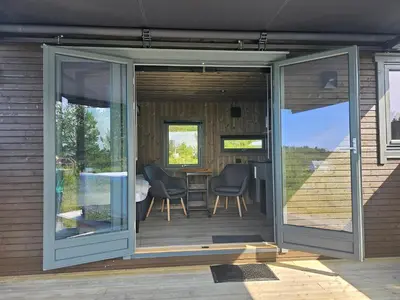 a screened in porch with a table and chairs at WayCamp Tustna in Leira