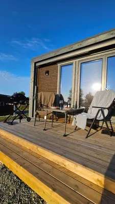 a wooden deck with a table and chairs on it at WayCamp Tustna in Leira