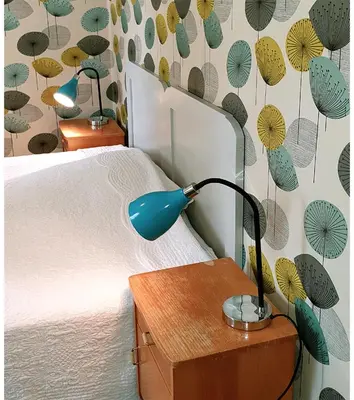 a blue lamp on a night stand next to a bed at Sanden pensjonat in Lærdalsøyri