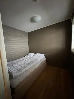 an unmade bed in a room with a wall at Cozy Apartment - Great View! in Håra