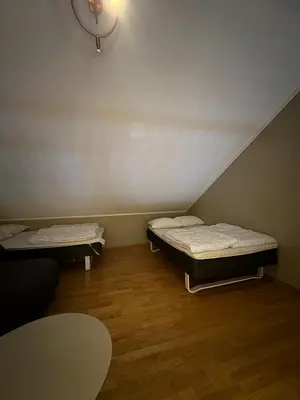 two beds in a small room with a table at Cozy Apartment - Great View! in Håra