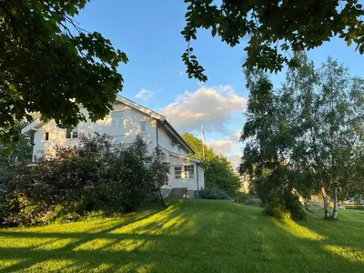 a house with a grassy yard next to a building at Historisk villa med klassiske detaljer in Snertingdal