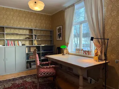 a home office with a wooden table and a window at Historisk villa med klassiske detaljer in Snertingdal