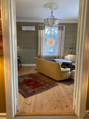 a living room with a couch and a table at Historisk villa med klassiske detaljer in Snertingdal
