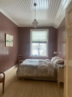 a bedroom with a large bed and a window at Historisk villa med klassiske detaljer in Snertingdal