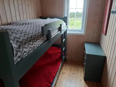 a bedroom with two bunk beds and a window at Trollbu by Norgesbooking - cabin at Golsfjellet in Sanderstølen