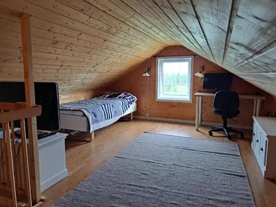 a bedroom with a bed in a wooden house at Trollbu by Norgesbooking - cabin at Golsfjellet in Sanderstølen