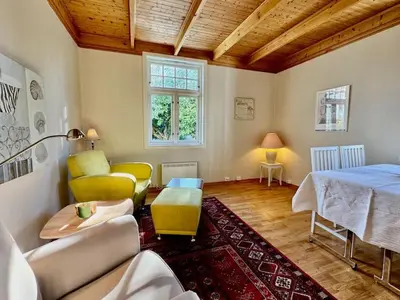 a living room with a couch and a bed and a table at Leilighet i herskapelig villa in Trondheim
