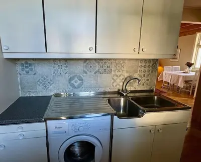 a kitchen with a sink and a washing machine at Leilighet i herskapelig villa in Trondheim