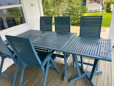 a blue picnic table and chairs on a porch at Hytte i Lysøysund med 4 soverom, Ørland in Lysøysund