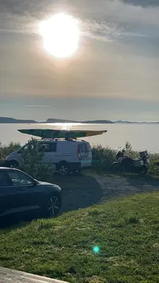 a white van with a surfboard on top of it at Hytte i Lysøysund med 4 soverom, Ørland in Lysøysund