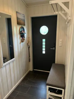 a black door in a room with a window at Hytte i Lysøysund med 4 soverom, Ørland in Lysøysund