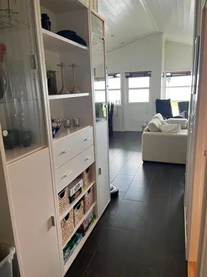 a kitchen with white cabinets and a living room at Hytte i Lysøysund med 4 soverom, Ørland in Lysøysund