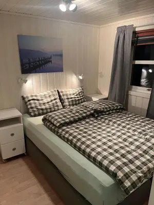 a bedroom with a bed with a plaid comforter at Hytte i Lysøysund med 4 soverom, Ørland in Lysøysund