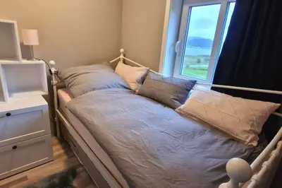 a bed in a room with a window at Haus Soltun-Was will man mehr! in Runde