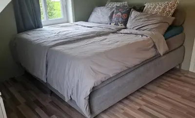 a bed with white sheets and pillows on it at Haus Soltun-Was will man mehr! in Runde