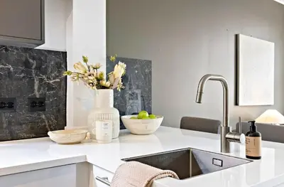 a kitchen with a sink and a vase of flowers at Koselig leilighet ved Solsiden in Trondheim