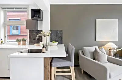 a kitchen and living room with a sink and a couch at Koselig leilighet ved Solsiden in Trondheim