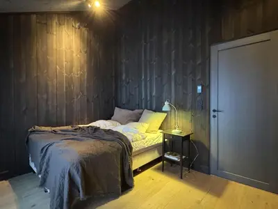 a bedroom with a bed and a lamp on a table at Spacious, exclusive and modern cabin in Geilo in Geilo