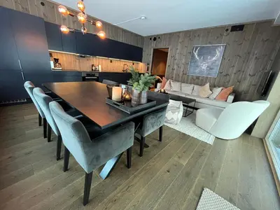 a dining room with a table and chairs and a couch at Exclusive Ski In-Out apartment in Hemsedal next to Fyri Resort in Hemsedal