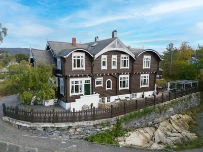 a large wooden house with a fence at Jervell 1 Bnb in Ålesund