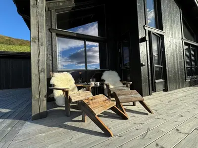 two benches sitting on a deck outside of a building at Roaldsida Retreat in Stranda