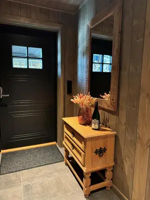 a black door and a bottle of wine on a table next to a door at Roaldsida Retreat in Stranda