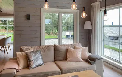 a living room with a brown couch in front of a window at 4 Bedroom Nice Home In Hildre in Hildre