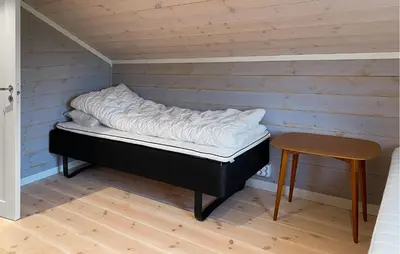 a bed in a room with a table and a stool at 4 Bedroom Nice Home In Hildre in Hildre