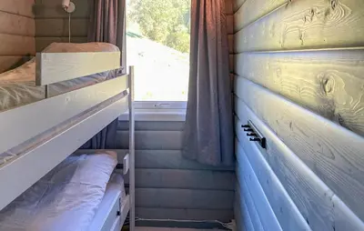 a small room with two bunk beds and a window at 5 Bedroom Cozy Home In Hebnes in Hebnes