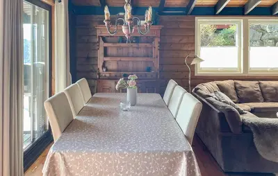a dining room with a table and a couch at 5 Bedroom Cozy Home In Hebnes in Hebnes